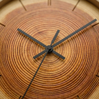 Wooden clock with black hands on a wooden background